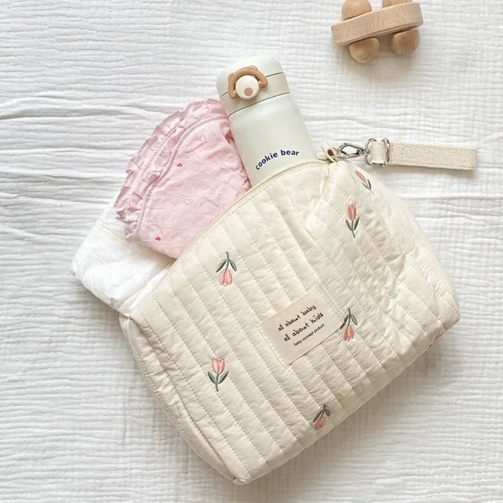 Pochette à langer nomade ouverte avec accessoires bébé